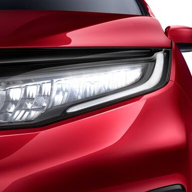 2027 Honda Odyssey Elite in Radiant Red Metallic II front clean studio background showing the detailed LED headlight (Minivan).